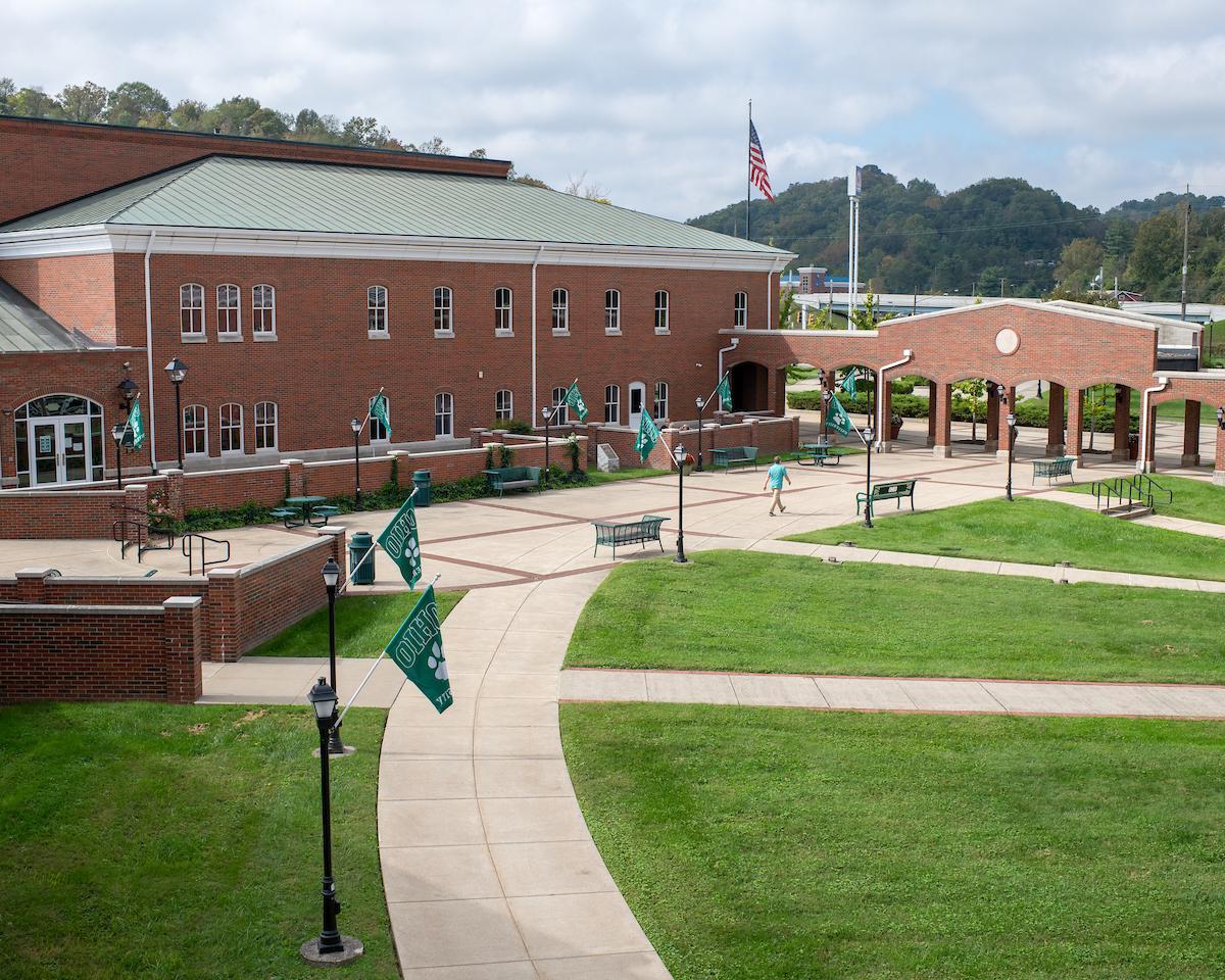 A courtyard with green grass surrounded by brick buildings