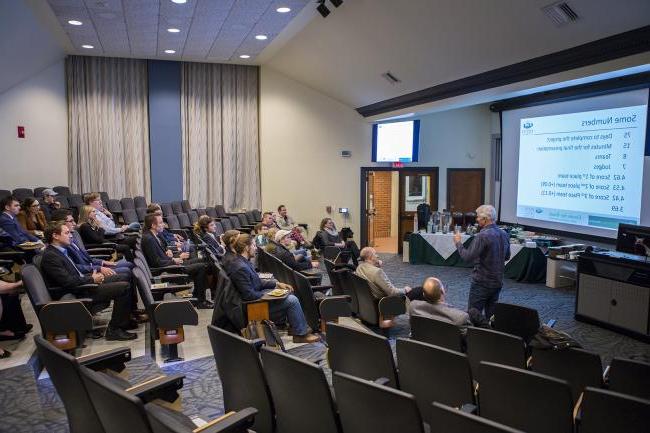 People in a lecture hall watching a presenter